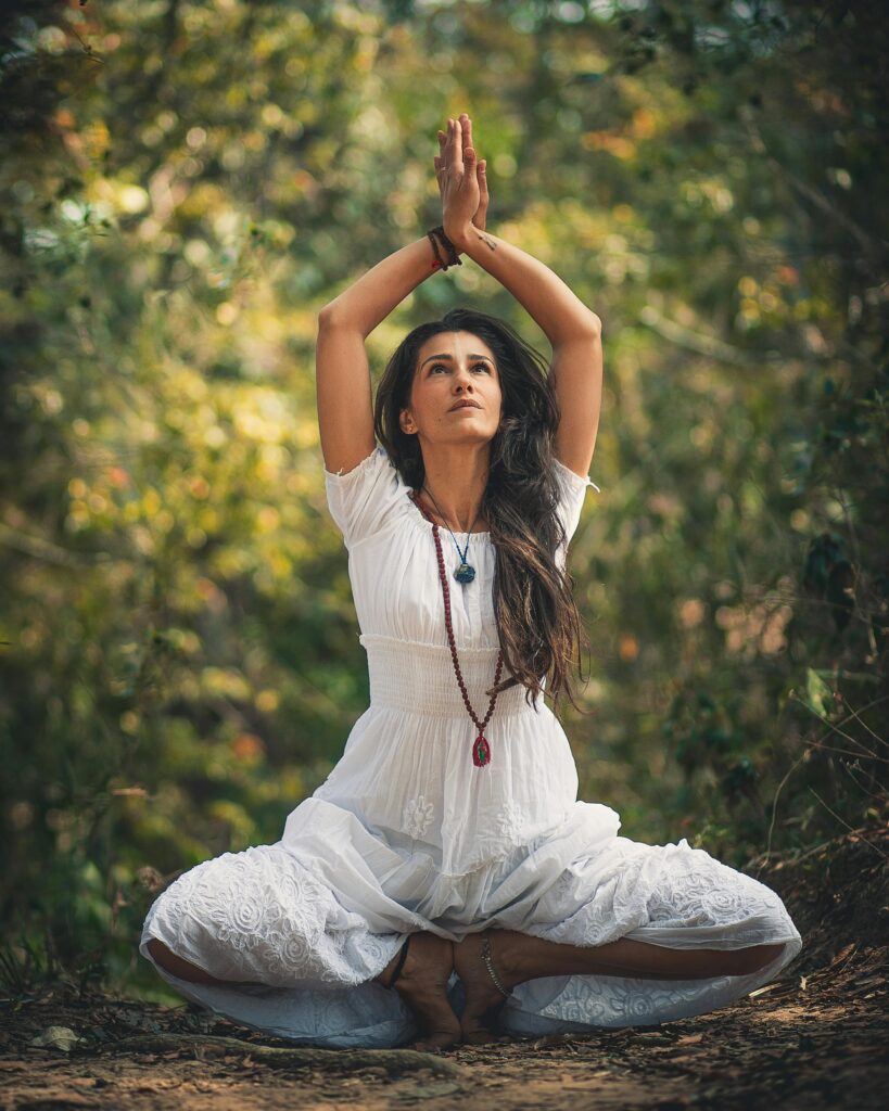 A woman meditating outdoors in a forest setting, embracing tranquility.